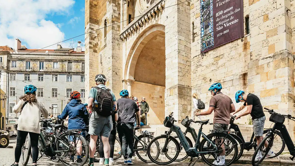 Cyclists on e-bikes at a miradouro overlooking the Tagus on a Lisbon city highlights and viewpoints e-bike tour