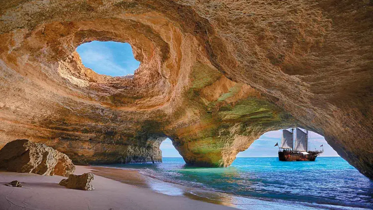The domed roof and beach inside Benagil sea cave on an Algarve day trip from Lisbon, Portugal